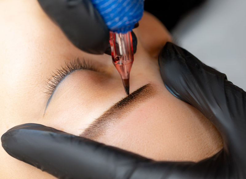 Powder brows tattooing in progress showing detailed cosmetic tattoo procedure