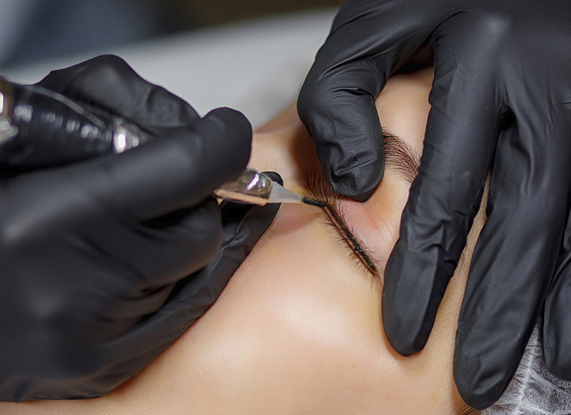 Eyeliner tattoo in progress showing precise cosmetic tattooing technique for permanent eyeliner